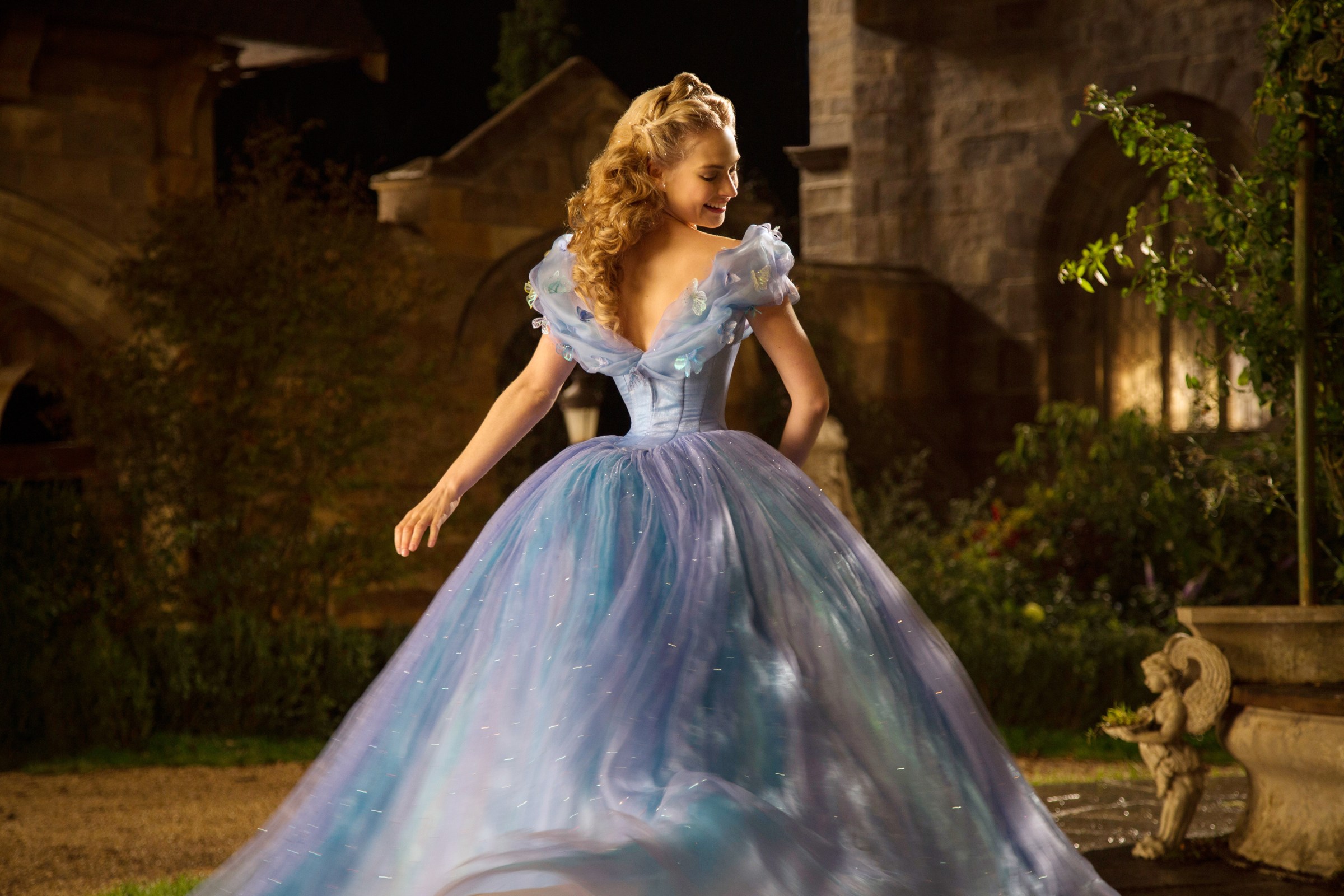 Lily James as Cinderella in the 2015 Disney live-action movie, twirling in her gorgeous ballgown.