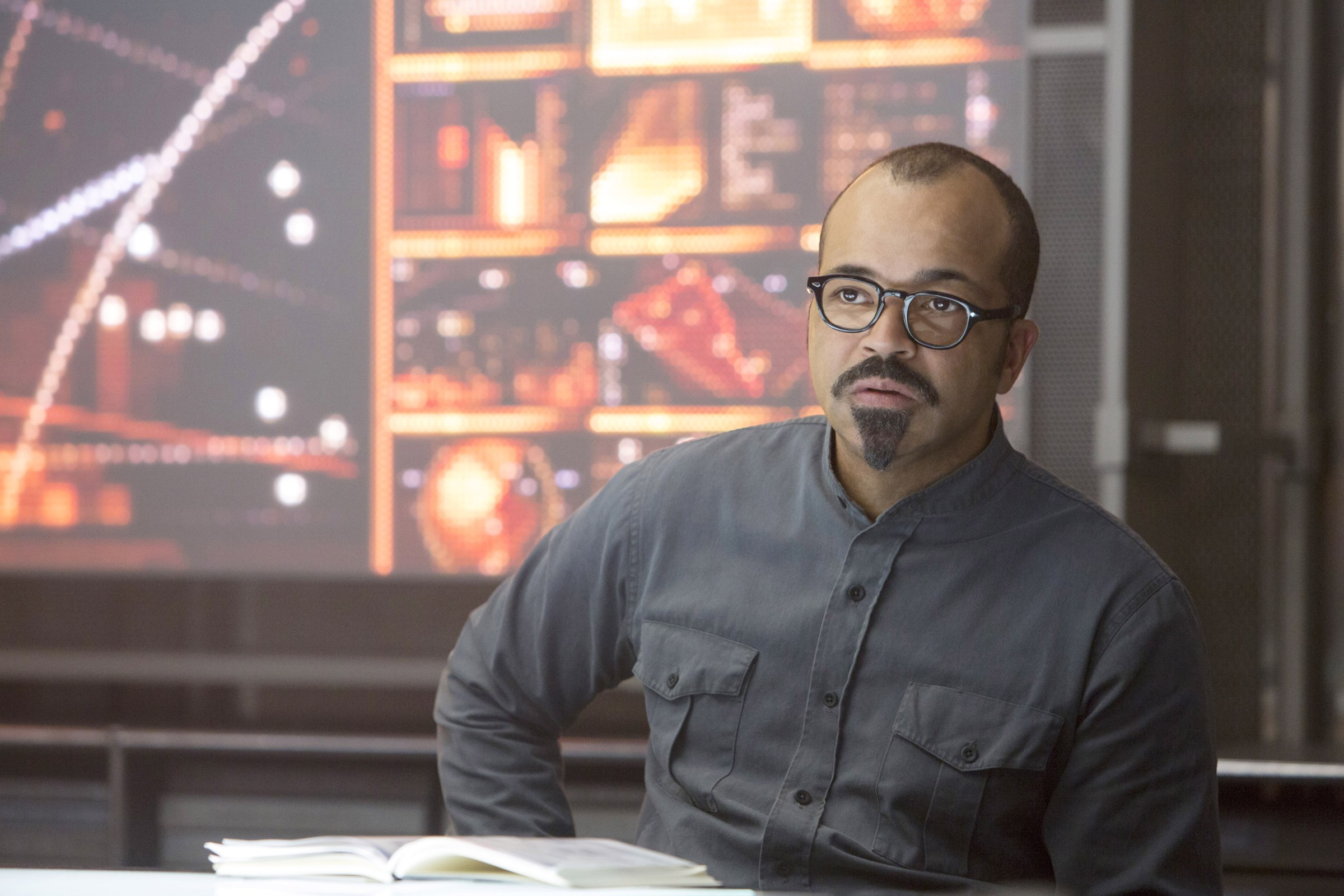 Jeffrey Wright as Beetee, sitting in a grey jumpsuit and looking serious in The Hunger Games: Mockingjay