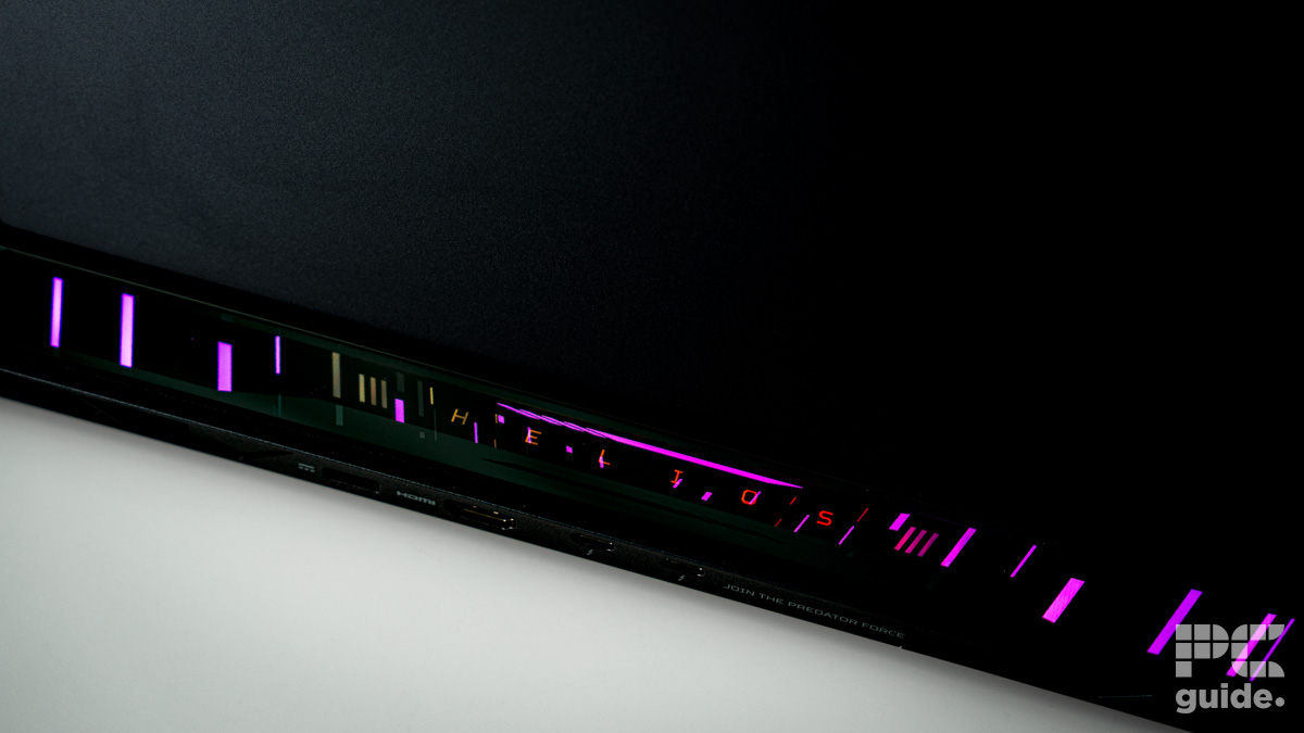 A close up on the rear RGB edge. In pink it reads HELIOS with strips surrounding it. It sits on a white table.