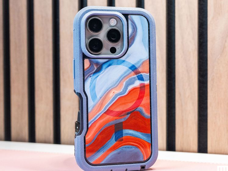 Back of a mobile phone that has an Otter Box Defender Series Pro XT With MagSafe, a case with blue trim and red and blue swirl interior design