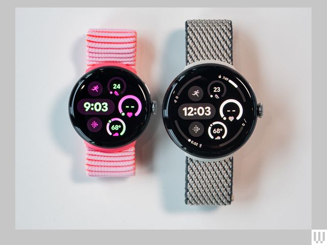 Top-down view of two digital smart watches side-by-side, one with a pink wristband and the other with black wristband.